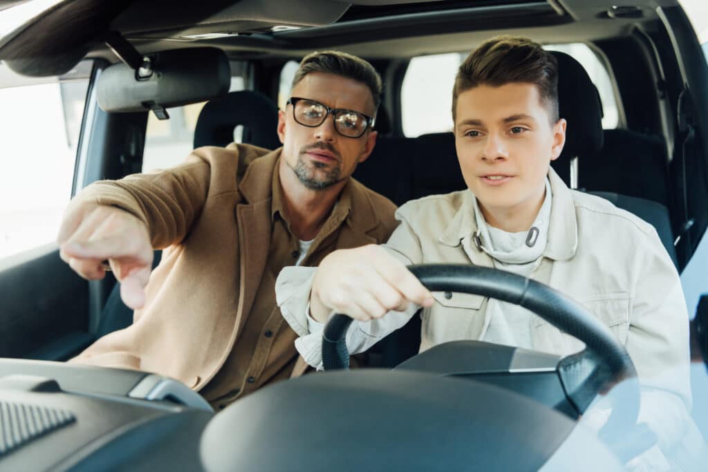 father teaching son how to drive safely