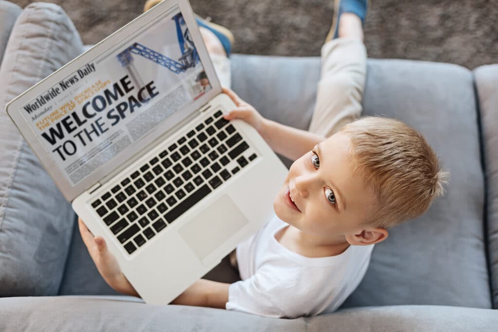 Boy looking at news on the laptop