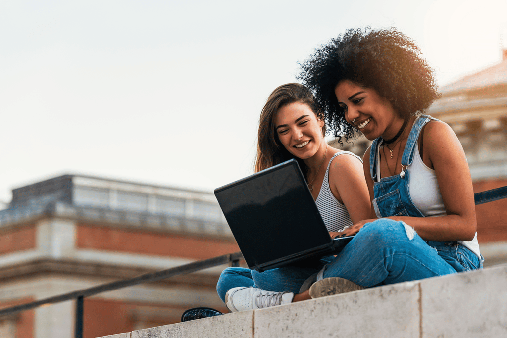 two teen girls smiling at a laptop