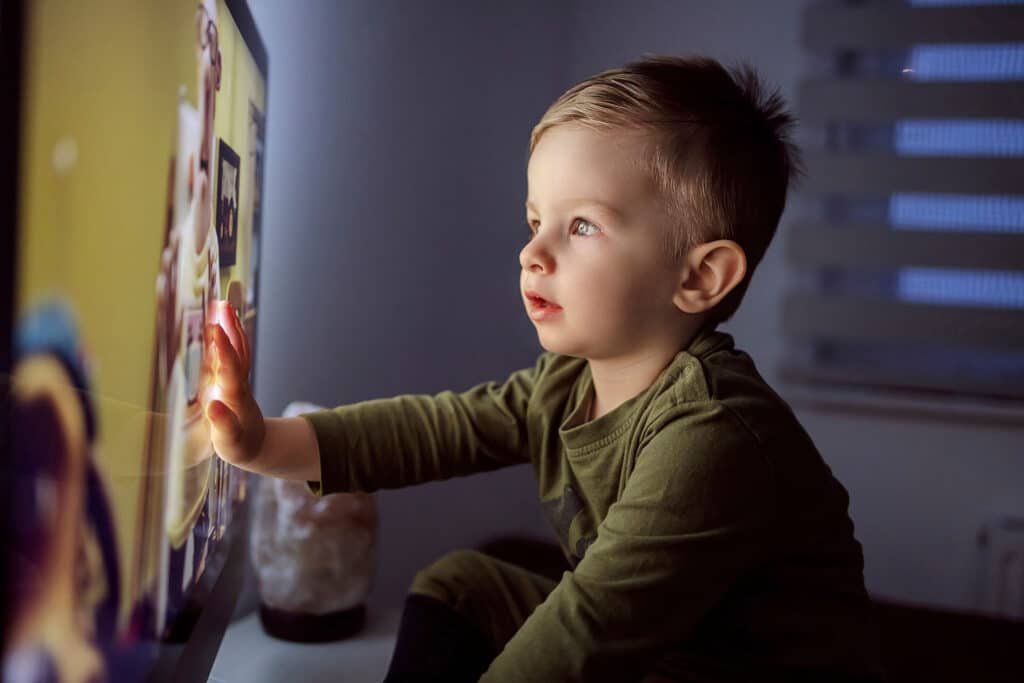 little boy touching a screen