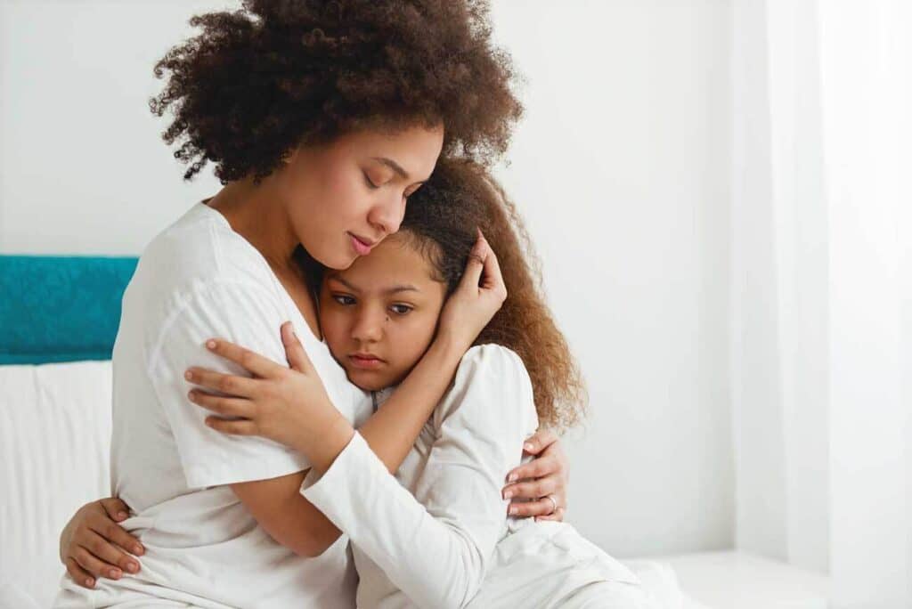 mother hugging her sad daughter