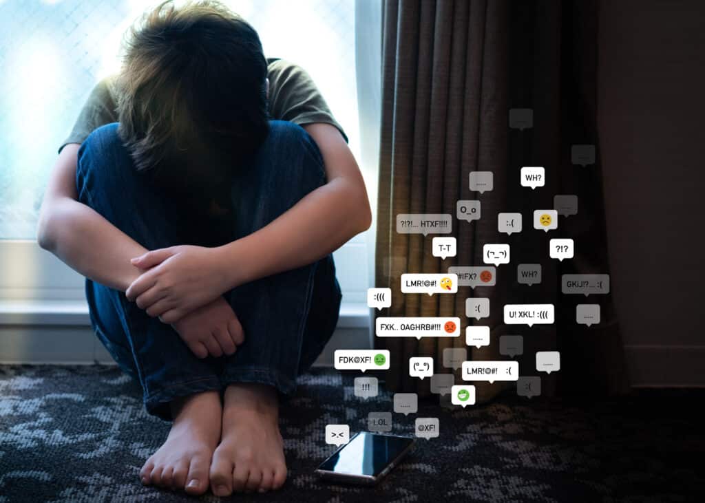 boy with head down surrounded by sad messages on cell phone