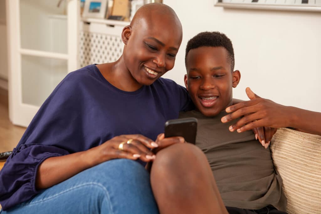mother and son smiling together at cellphone